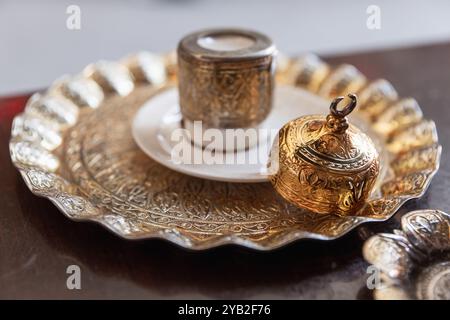 Le café turc est servi dans une tasse vintage de luxe avec une décoration arabesque dorée. Gros plan avec flou sélectif Banque D'Images