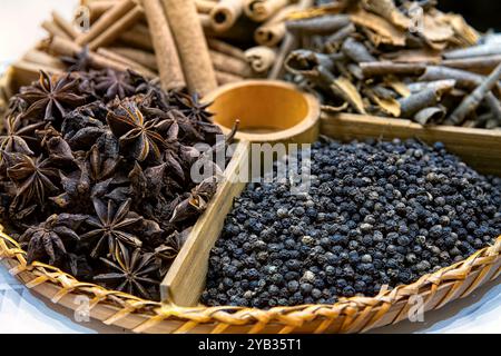 Épices indiennes entières pour faire Garam Masala dans une assiette en bois, vue de dessus. Banque D'Images