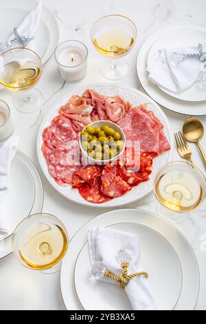 Cadre festif avec assiette de viande et vin assortis Banque D'Images