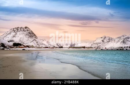Ramberg Beach ou Rambergstranda en hiver sur les îles Lofoten, Norvège au coucher du soleil. Paysage d'hiver avec des montagnes enneigées, plage de sable du nord et clair Banque D'Images