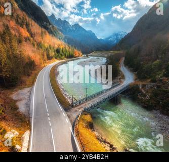 Vue aérienne de la route de montagne sinueuse et de la rivière au coucher du soleil. Automne Banque D'Images