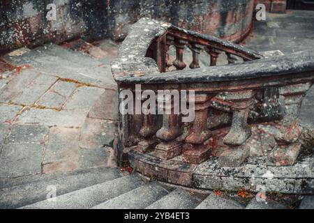 Escalier en pierre altérée avec balustrade ornée de colonnes érodées ornées. Les étapes montrent des signes de vieillissement, avec de la mousse et du lichen poussant sur le STO Banque D'Images