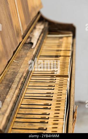 Vieux piano antique manquant des touches avec des dommages évidents de l'eau de bois. Une photographie originale de piano vintage avec les touches tombant au loin. Banque D'Images