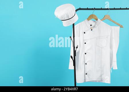 Uniforme du chef sur le porte-vêtements sur fond bleu clair, espace pour le texte Banque D'Images