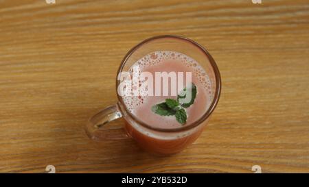 Jus de pastèque garni de menthe rafraîchissant dans une tasse en verre Banque D'Images