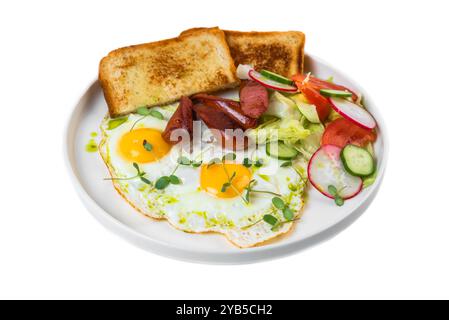 Petit déjeuner anglais sain avec œufs frits, saucisses, toasts et salade dans une assiette blanche sur fond blanc Banque D'Images