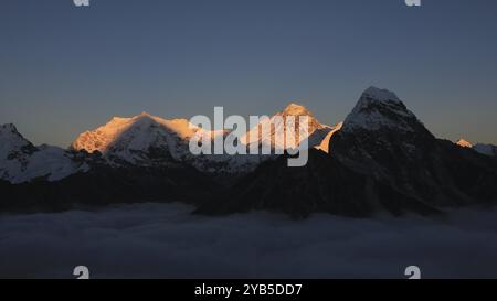 Lumineux Mont Everest éclairé au coucher du soleil, mer de brouillard, Népal, Asie Banque D'Images