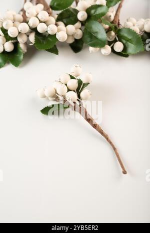 Baies artificielles sur un fil pour le travail à l'aiguille et la décoration de cadeaux, couronnes sur fond blanc Banque D'Images