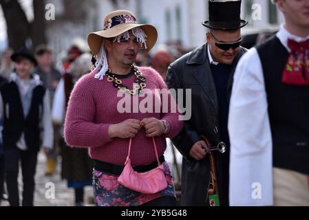 RIMETEA, ROUMANIE - 2 MARS 2024 : des hommes non identifiés vêtus de vêtements féminins célébrant le carnaval à la fin de l'hiver Banque D'Images