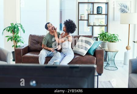 Homme, femme et jeu vidéo avec attention pour l'esport, drôle et ludique à la maison pour le collage. Couple, contrôleur et ensemble dans le salon sur Banque D'Images
