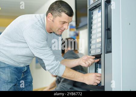 homme dans le distributeur automatique de café Banque D'Images