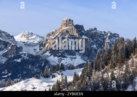 La majestueuse montagne Sassongher dans les Dolomites brille par la douce lumière du soir. Le paysage enneigé et les ombres contrastées créent une magie Banque D'Images