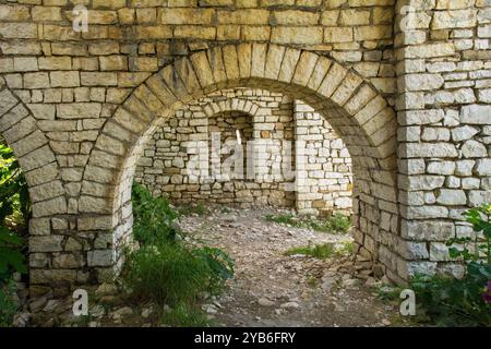 Ouvertures en arc de cercle dans une ruine de la citadelle du XIIIe siècle dans le château de Berat, Albanie. Mélange d'architecture byzantine, ottomane et médiévale. Classé UNESCO Banque D'Images