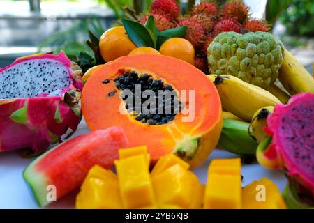 Gros plan de la coupe femelle de fruits de papaye mûrs sur une planche à découper dans la cuisine, ralenti. Mode de vie sain et concept d'aliments biologiques naturels Banque D'Images