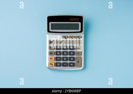 Vue de dessus de la calculatrice électronique sur fond bleu Banque D'Images