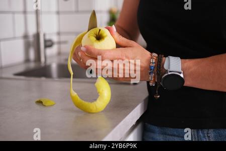 Fille nettoie Apple en vue rapprochée dans la cuisine Banque D'Images