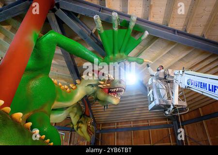 Hahnenklee, Allemagne. 17 octobre 2024. Un peintre travaille sur un dragon à trois têtes sur le Bocksberg dans les montagnes du Harz. Le dragon est assemblé dans le cadre d'une nouvelle piste de luge estivale. L'attraction devrait être terminée en 2025. Crédit : Swen Pförtner/dpa/Alamy Live News Banque D'Images