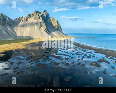 Vue aérienne de Mt. Vestrahorn , plage de lave noire, reflets sur l'eau, Stokksnes, à l'est de Höfn, Fjords de l'est, Islande Banque D'Images