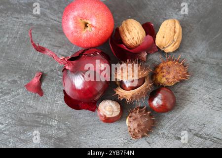 Fond d'automne avec des châtaignes, des noix et des pommes de pin sur fond noir. Décoration naturelle de la saison d'automne. Banque D'Images