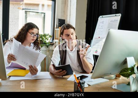 Une jeune femme de grande taille et son ami masculin s'engagent dans une discussion animée tout en travaillant ensemble. Banque D'Images