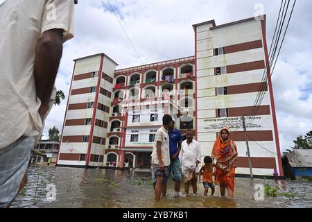 Les populations touchées par les inondations se sont réfugiées dans un bâtiment scolaire du district de Feni, au Bangladesh, le 24 août 2024. Banque D'Images