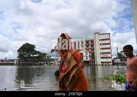 Les populations touchées par les inondations se sont réfugiées dans un bâtiment scolaire du district de Feni, au Bangladesh, le 24 août 2024. Banque D'Images