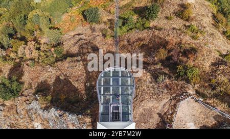 Sasso di Castalda, Italie - août 2024 : une vue aérienne capture une longue passerelle suspendue s'étendant sur un terrain rocheux avec un vert environnant A. Banque D'Images