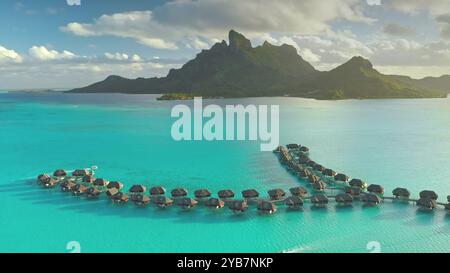 Complexe bungalows sur l'eau bordant le lagon bleu turquoise de l'île de Bora Bora en Polynésie française. Destination touristique populaire. Paradis sauvage isolé, voyage exotique d'été, lune de miel romantique Banque D'Images