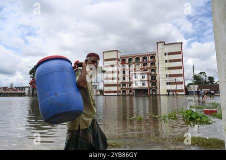 Les populations touchées par les inondations se sont réfugiées dans un bâtiment scolaire du district de Feni, au Bangladesh, le 24 août 2024. Banque D'Images