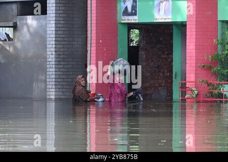 Les populations touchées par les inondations se sont réfugiées dans un bâtiment scolaire du district de Feni, au Bangladesh, le 24 août 2024. Banque D'Images