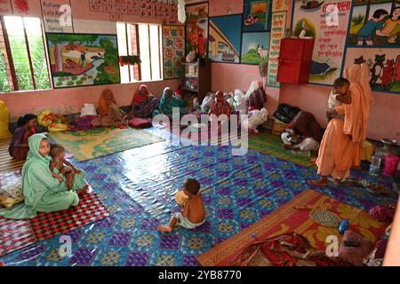 Les populations touchées par les inondations se sont réfugiées dans un bâtiment scolaire du district de Feni, au Bangladesh, le 24 août 2024. Banque D'Images