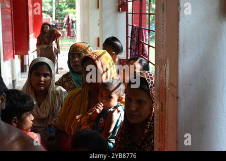 Les populations touchées par les inondations se sont réfugiées dans un bâtiment scolaire du district de Feni, au Bangladesh, le 24 août 2024. Banque D'Images