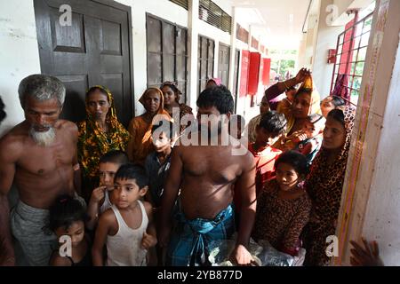 Les populations touchées par les inondations se sont réfugiées dans un bâtiment scolaire du district de Feni, au Bangladesh, le 24 août 2024. Banque D'Images