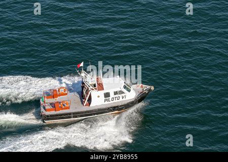 Manzanillo, Colima, Mexique - 16 janvier 2024 : un bateau-pilote qui accélère aux côtés d'un bateau de croisière pour l'escorter dans le port de Manzanillo. Banque D'Images