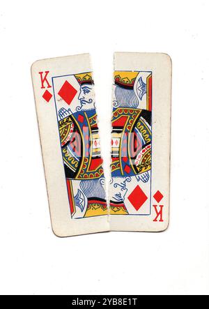 Une carte à jouer vintage déchirée en deux de haut en bas sur un fond blanc. Banque D'Images