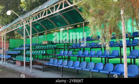 chaises en plastique vides sous un auvent sur une petite tribune extérieure pour regarder des courses de chevaux ou des jeux sportifs, un auditorium ouvert d'été sans personne Banque D'Images