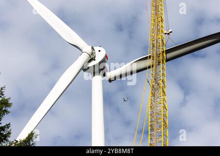 Fribourg, Allemagne. 17 octobre 2024. Une grue lève la troisième pale de rotor d'une nouvelle éolienne sur le Holzschlägermatte sur le Schauinsland. La turbine devrait fournir trois fois la puissance de la turbine précédente, qui a été démolie l'année dernière après 20 ans d'exploitation. Crédit : Philipp von Ditfurth//dpa/Alamy Live News Banque D'Images