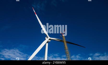 Fribourg, Allemagne. 17 octobre 2024. Une grue lève la troisième pale de rotor d'une nouvelle éolienne sur le Holzschlägermatte sur le Schauinsland. La turbine devrait fournir trois fois la puissance de la turbine précédente, qui a été démolie l'année dernière après 20 ans d'exploitation. Crédit : Philipp von Ditfurth//dpa/Alamy Live News Banque D'Images