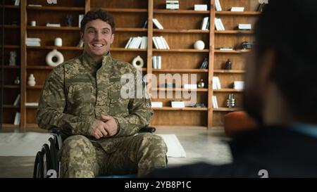 Heureux sourire riant caucasien officier homme camouflage uniforme homme avec handicap soldat militaire Guy en fauteuil roulant parlant mentale Banque D'Images