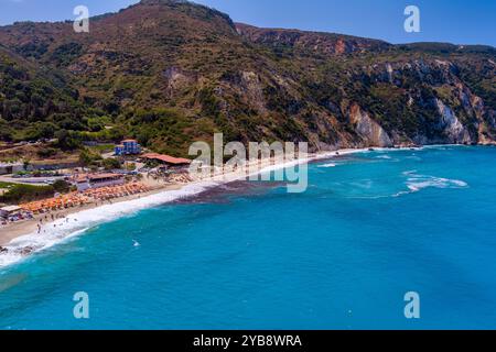 Entouré de falaises, la plage Petani Beach de Céphalonie présente des eaux turquoises, du sable doré. Il est idéal pour nager et se détendre, avec des chaises longues et Banque D'Images