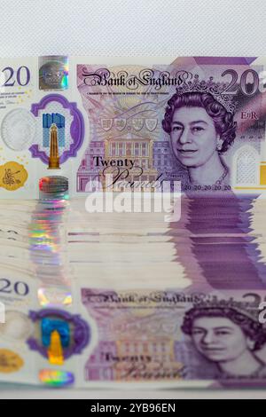 Gros plan d'une pile de billets britanniques de 20 livres avec un focus sur la note du haut avec un portrait de la reine Elizabeth II et une fea holographique de sécurité Banque D'Images