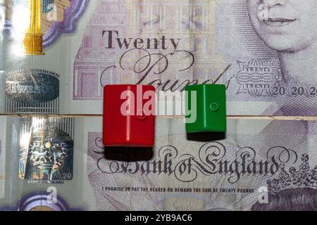 Vue rapprochée d'un billet de vingt livres de la Banque d'Angleterre, avec un portrait et des motifs complexes. Deux petits blocs en plastique, un rouge et Banque D'Images