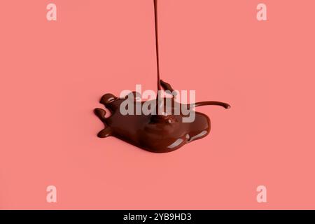 Goutte à goutte chocolat sucré sur fond rouge Banque D'Images