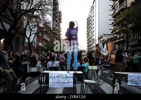 Buenos Aires, Argentine. 16 octobre 2024. Un étudiant se tient debout sur une table pendant qu'une classe publique se tient dans les rues de Buenos Aires pendant la manifestation. Au milieu de l'escalade du conflit entre le gouvernement et les universités publiques, les syndicats étudiants de l'Université de Buenos Aires (UBA) ont organisé une marche aux flambeaux de la Plaza Houssay au Palais Pizzurno, le siège du ministère de l'éducation, ''pour défendre des universités publiques libres et de qualité''. Ils ont été rejoints par des syndicats représentant les enseignants et les diplômés. (Crédit image : © Santi Garcia Diaz/SOPA images via ZUMA Press Wire) EDITORI Banque D'Images