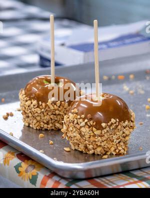 Les pommes au caramel fraîchement trempées reposent sur une plaque de cuisson avant d'être emballées et vendues Banque D'Images