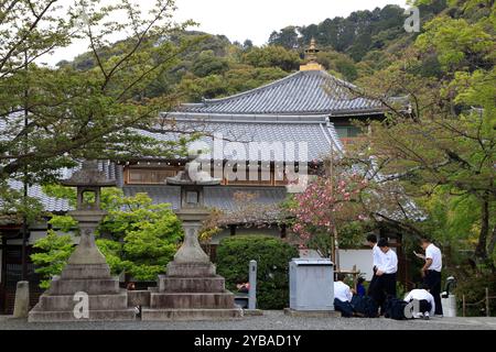 Lanternes de pierre et un groupe d'étudiants dans le temple Kiyomizu-dera. Kyoto, Japon Banque D'Images