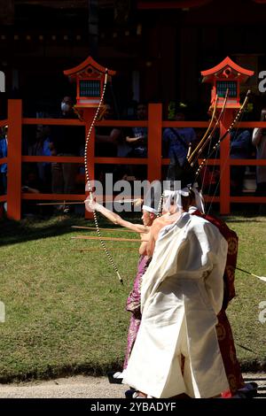 Archers masculins en robe de cérémonie traditionnelle et pièce de tête visant la cible dans le champ de tir lors d'une cérémonie Kyūdō qui a lieu au sanctuaire Kasuga Taisha. Nara, Japon Banque D'Images