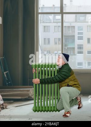 Un homme se réchauffe sur un radiateur sur un chantier de construction Banque D'Images
