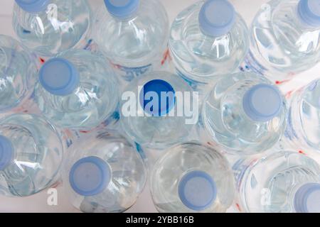 Vue de dessus des bouteilles d'eau avec une impaire avec un bouchon bleu foncé. Banque D'Images