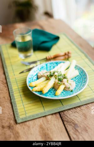 Plat fait maison avec des asperges blanches avec une sauce à la crème de noix de cajou, garni de persil haché. Banque D'Images